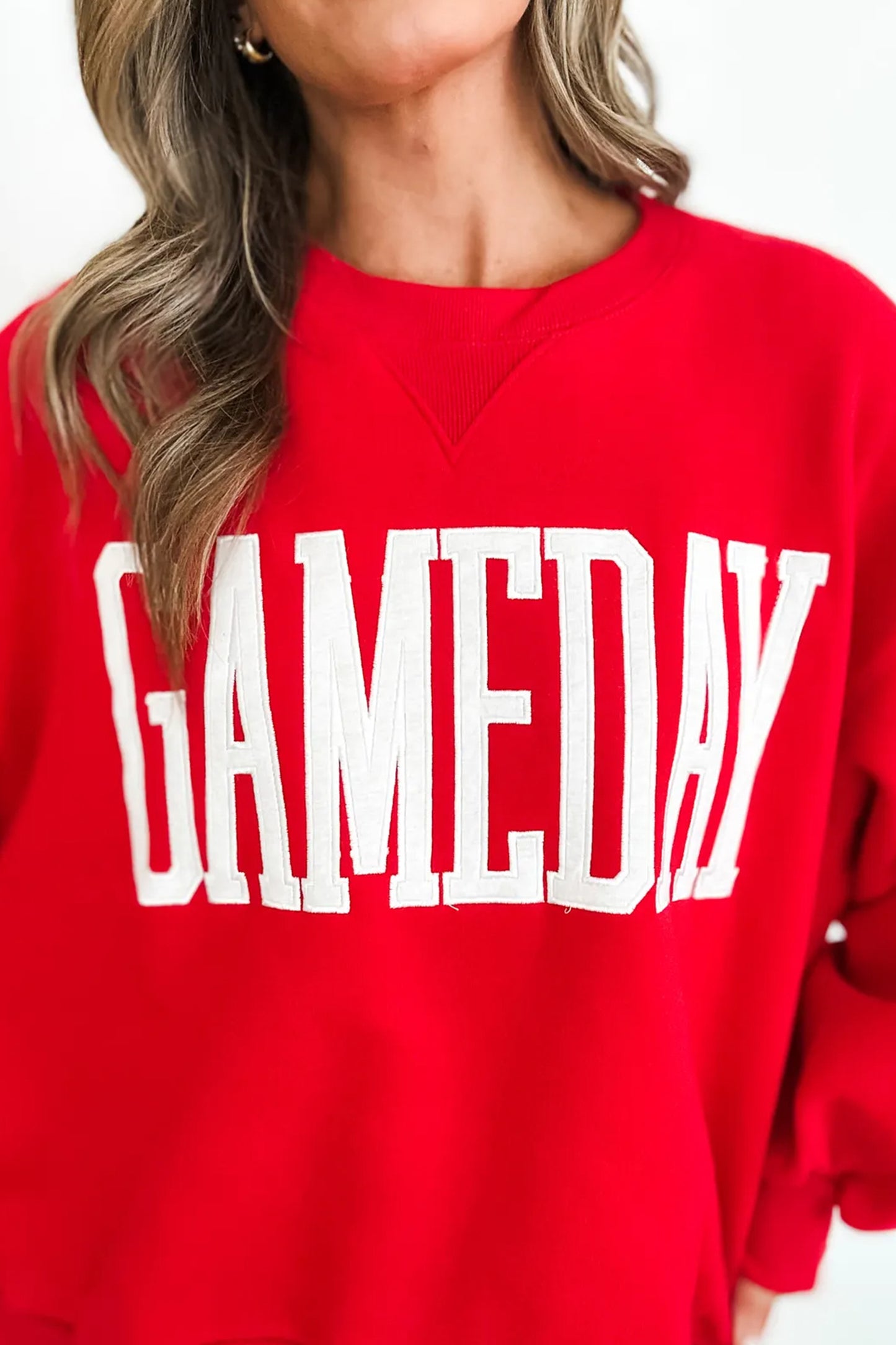 Red sweatshirt with 'GAMEDAY' text worn by a person