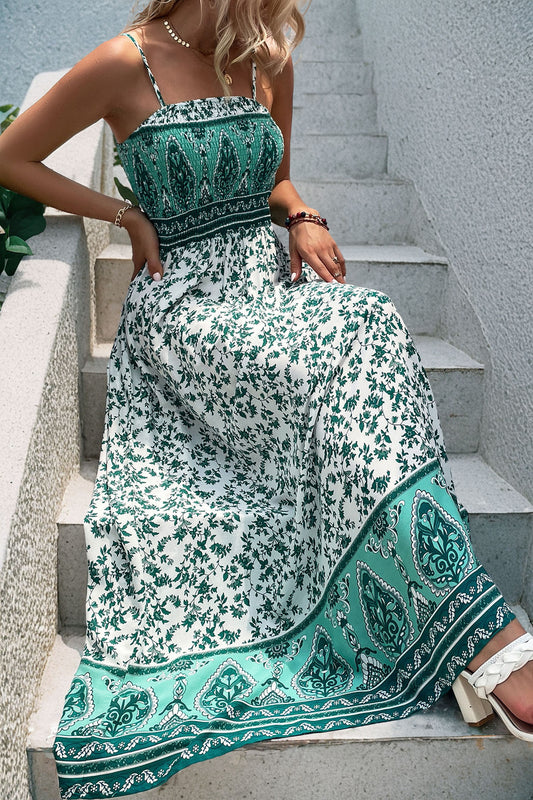 Person wearing a green and white patterned dress sitting on stairs.