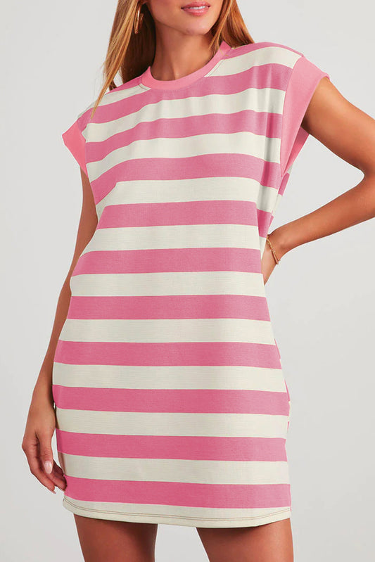 Woman wearing a pink and white striped dress on a plain background